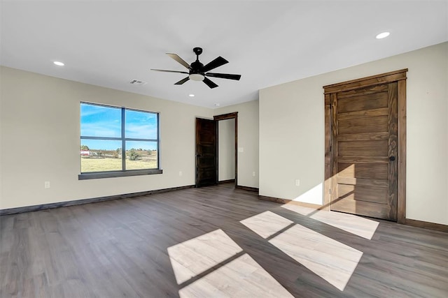 unfurnished bedroom featuring ceiling fan and dark hardwood / wood-style flooring