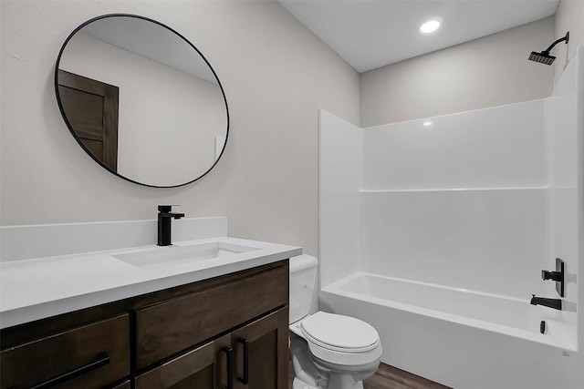 full bathroom with hardwood / wood-style floors, vanity, shower / bathtub combination, and toilet