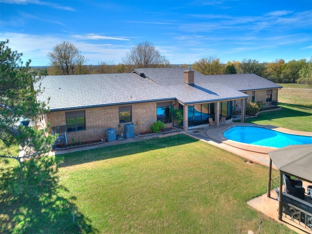 rear view of property featuring a yard and a patio