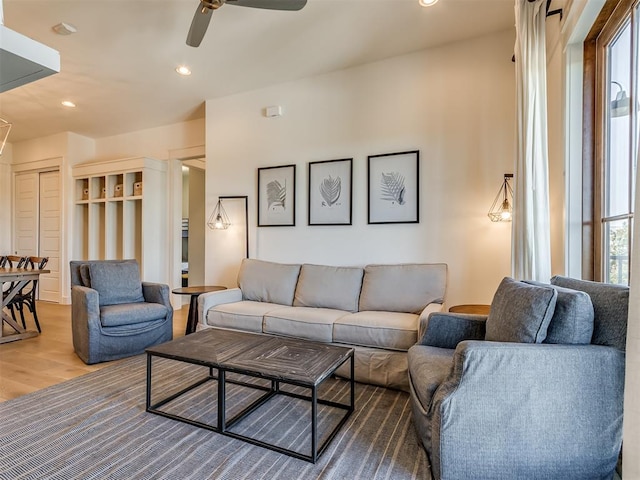 living room with wood-type flooring and ceiling fan