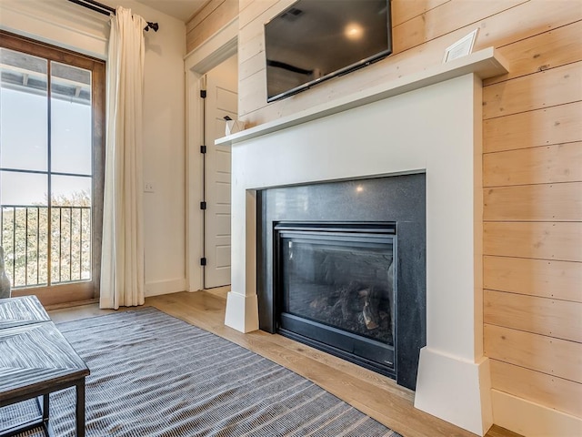 room details with wood walls and hardwood / wood-style flooring