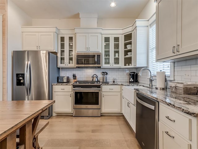 kitchen with light stone counters, white cabinets, and stainless steel appliances