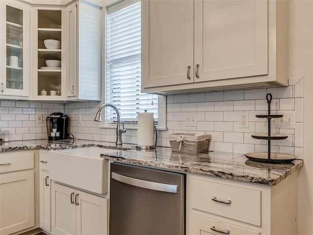 kitchen featuring sink, light stone counters, stainless steel dishwasher, decorative backsplash, and white cabinets