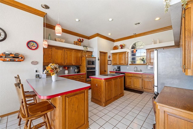 kitchen with a center island, sink, stainless steel appliances, pendant lighting, and a kitchen bar