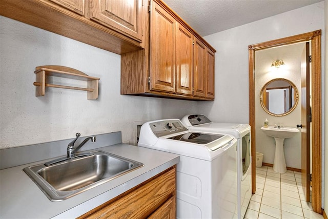 washroom with separate washer and dryer, sink, light tile patterned floors, and cabinets