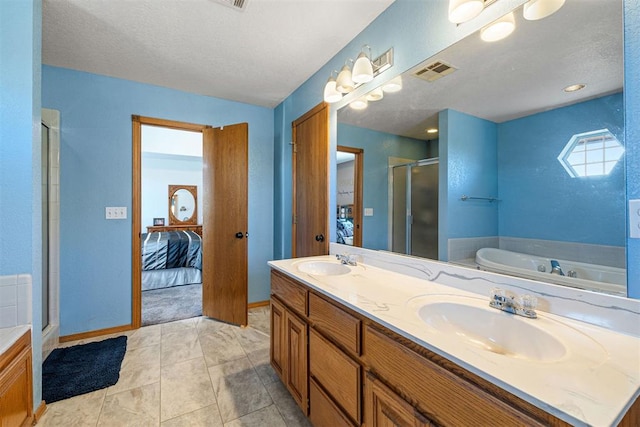 bathroom featuring tile patterned flooring, shower with separate bathtub, vanity, and a textured ceiling