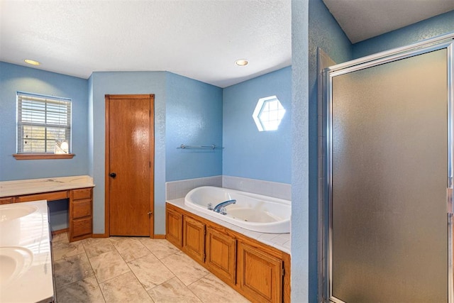 bathroom featuring separate shower and tub, vanity, and a textured ceiling