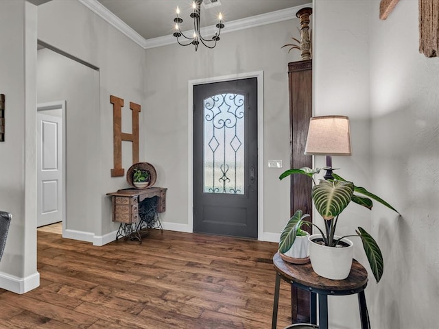 entryway with dark hardwood / wood-style floors, crown molding, and an inviting chandelier