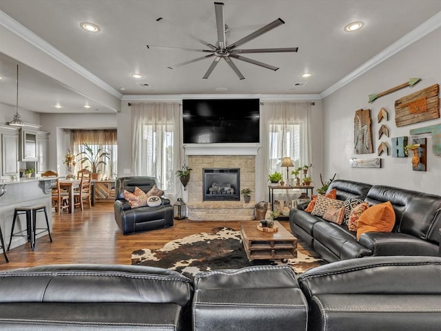 living room featuring a fireplace, ceiling fan, hardwood / wood-style floors, and ornamental molding