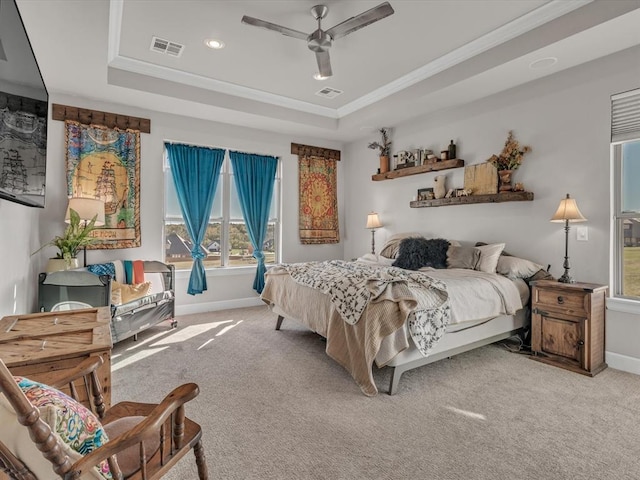 carpeted bedroom with a tray ceiling, ceiling fan, and ornamental molding