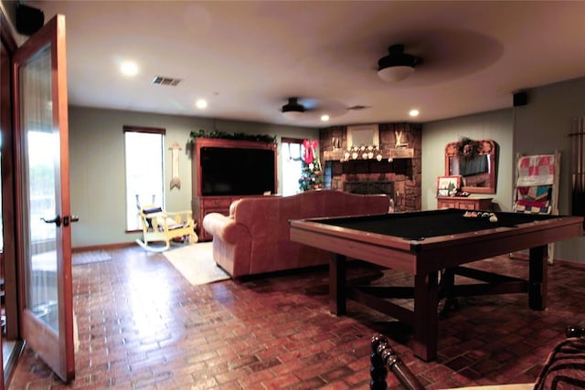 recreation room with a large fireplace, ceiling fan, and billiards