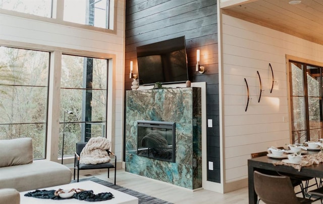 living room featuring wood-type flooring, wooden ceiling, and wood walls