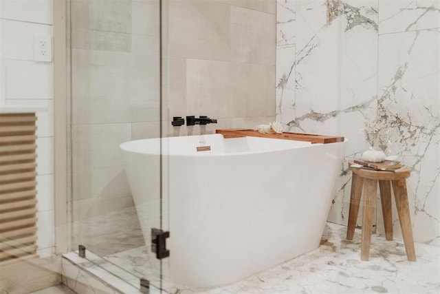 bathroom featuring separate shower and tub and tile walls