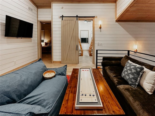 living room with a barn door, hardwood / wood-style flooring, wooden walls, and wood ceiling