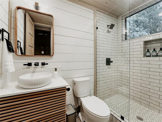 bathroom featuring vanity, toilet, walk in shower, and wooden walls