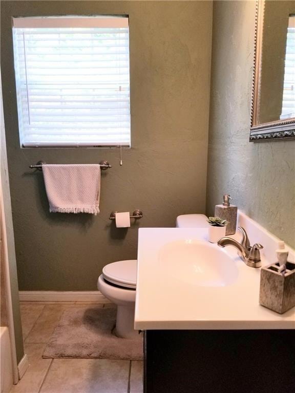 bathroom with tile patterned floors, vanity, toilet, and a bath