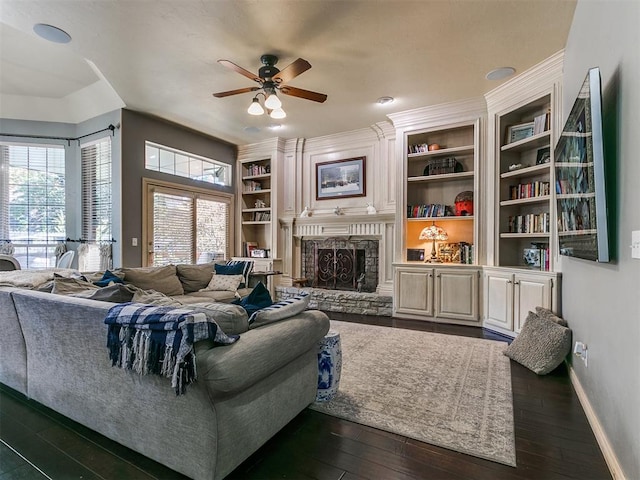 living room featuring a fireplace, ceiling fan, dark wood-type flooring, and built in shelves