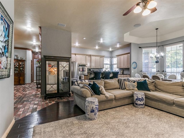 living room with ceiling fan with notable chandelier