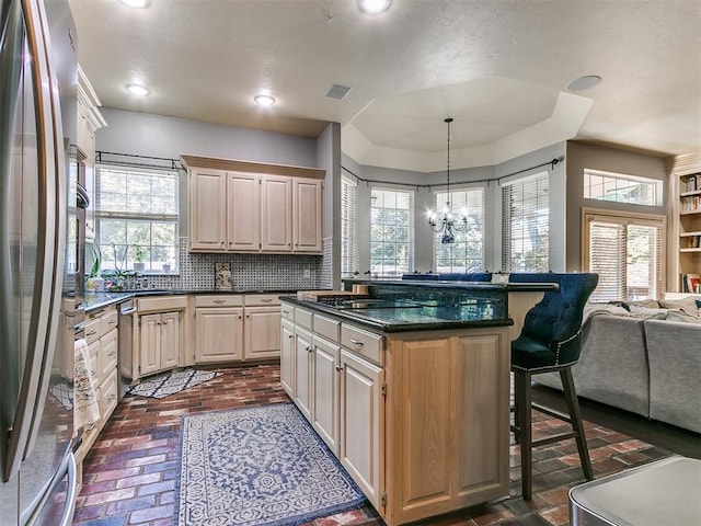 kitchen featuring hanging light fixtures, stainless steel appliances, an inviting chandelier, and plenty of natural light