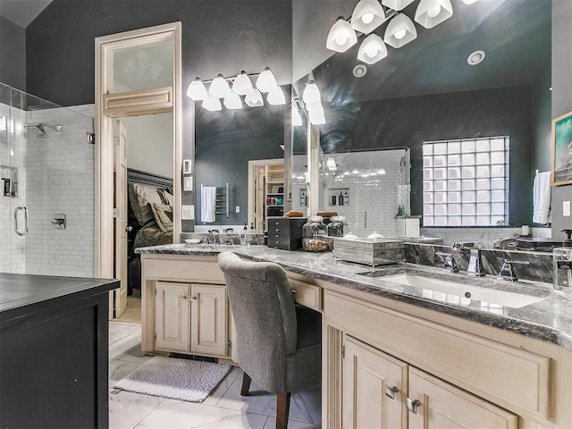 bathroom featuring a shower with door and vanity