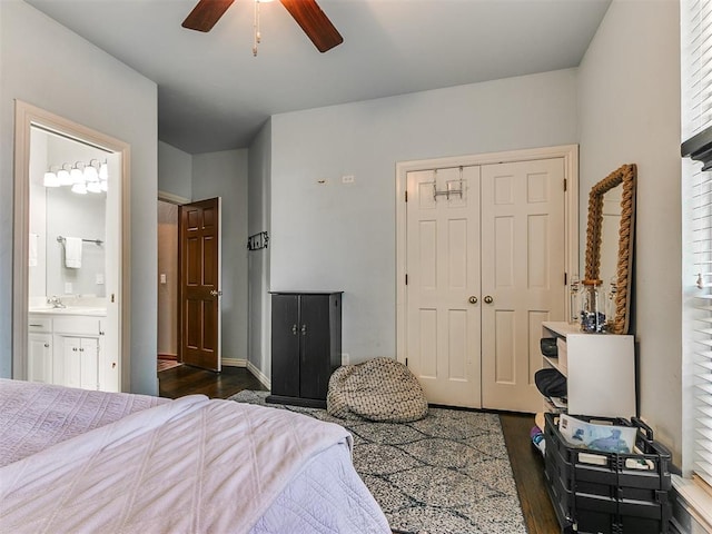 bedroom featuring dark hardwood / wood-style flooring, ensuite bathroom, ceiling fan, sink, and a closet