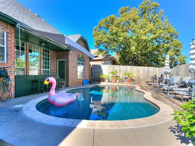 view of swimming pool with a bar and a patio