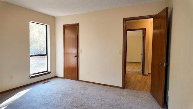 carpeted spare room with a textured ceiling