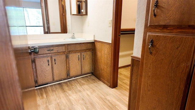 bathroom featuring vanity, hardwood / wood-style flooring, and wood walls