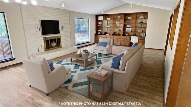 living room with lofted ceiling, a fireplace, and light hardwood / wood-style flooring