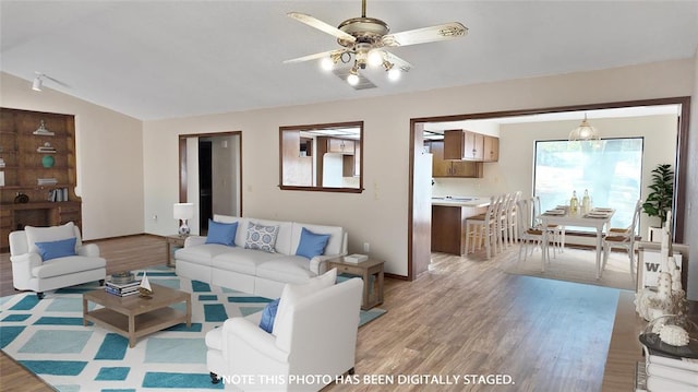 living room featuring ceiling fan, lofted ceiling, and light hardwood / wood-style floors