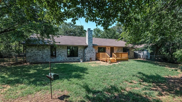 rear view of property with a wooden deck and a yard