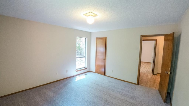 unfurnished bedroom with light carpet and a textured ceiling