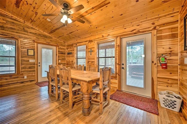 dining area featuring wooden walls, plenty of natural light, wooden ceiling, and light hardwood / wood-style flooring