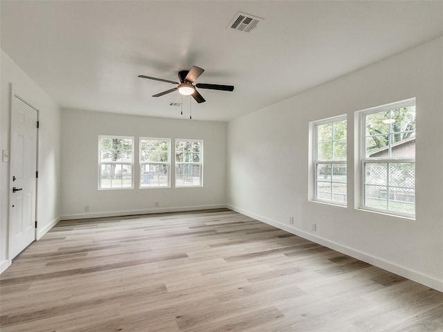 spare room with a wealth of natural light, light hardwood / wood-style flooring, and ceiling fan