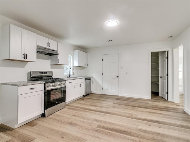 kitchen with white cabinetry, sink, a healthy amount of sunlight, stainless steel appliances, and light wood-type flooring