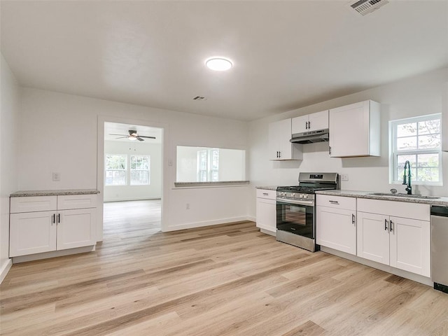 kitchen with white cabinets, appliances with stainless steel finishes, plenty of natural light, and sink