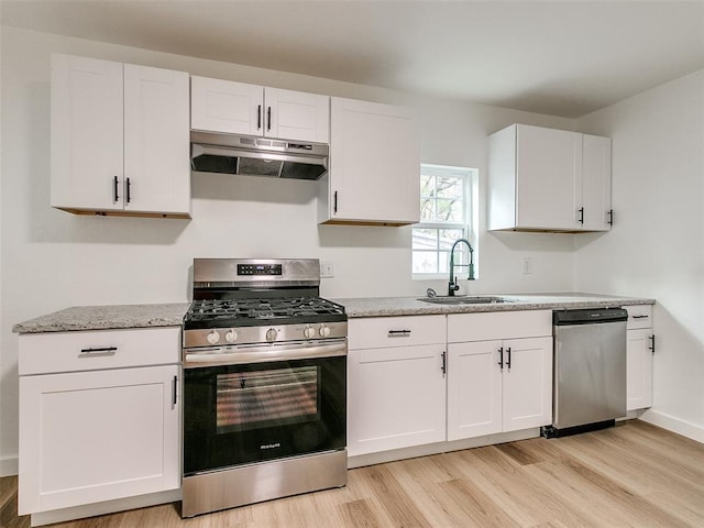 kitchen featuring white cabinetry, sink, stainless steel appliances, and light hardwood / wood-style floors