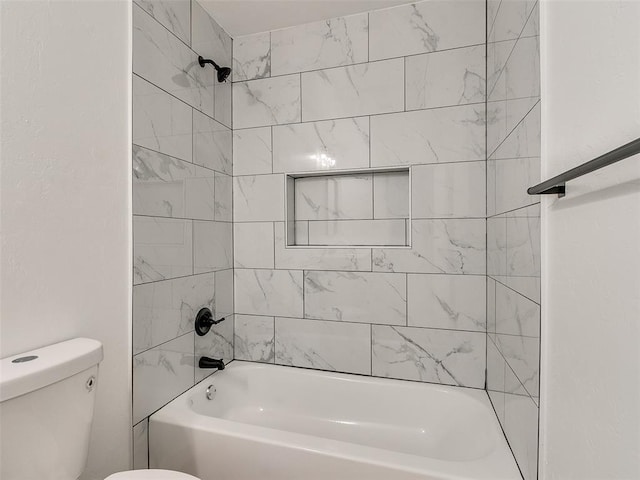 bathroom with tiled shower / bath combo and toilet