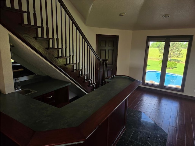 entrance foyer featuring a textured ceiling, dark hardwood / wood-style flooring, and sink