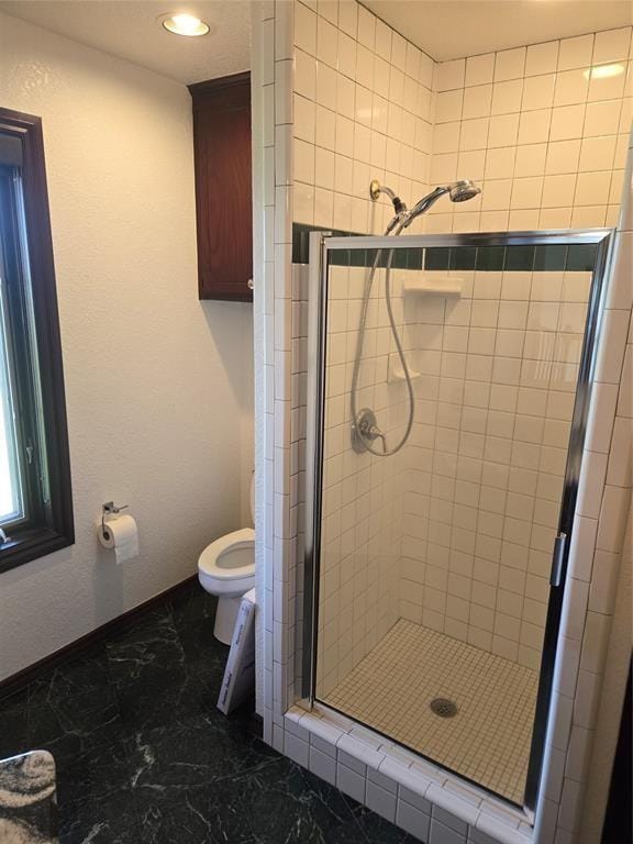 bathroom featuring toilet and an enclosed shower