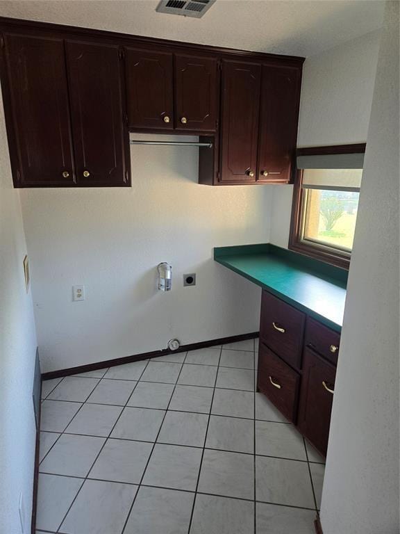 kitchen featuring dark brown cabinetry and light tile patterned floors