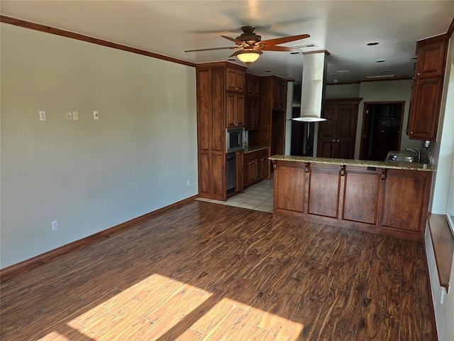 kitchen featuring stainless steel microwave, light hardwood / wood-style flooring, ornamental molding, range hood, and kitchen peninsula