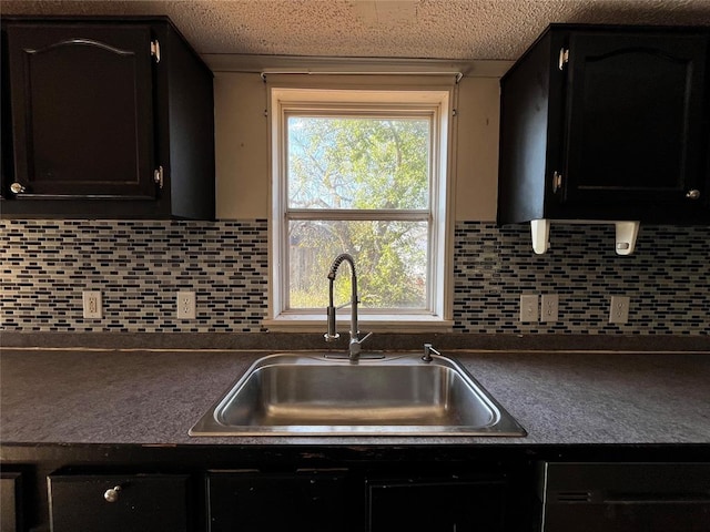 kitchen featuring backsplash, dishwashing machine, and sink