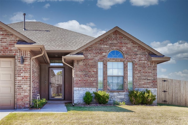 entrance to property featuring a yard and a garage