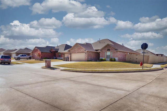 4536 Oasis Ct, Yukon, OK 73099 - view of front of home featuring brick siding, an attached garage, concrete driveway, and a residential view