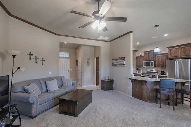 living room with sink, ceiling fan, light colored carpet, and crown molding