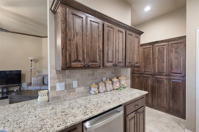 kitchen featuring light stone countertops, dark brown cabinetry, stainless steel dishwasher, and backsplash