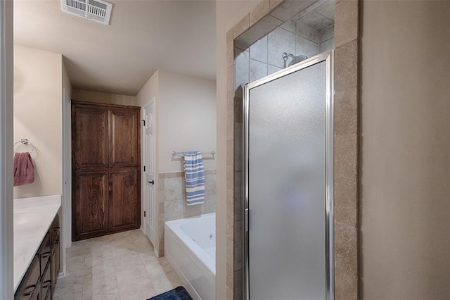 bathroom featuring shower with separate bathtub, vanity, tile patterned floors, and tile walls