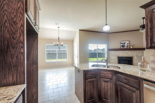 4536 Oasis Ct, Yukon, OK 73099 - kitchen featuring dishwasher, a tile fireplace, a sink, a chandelier, and a peninsula