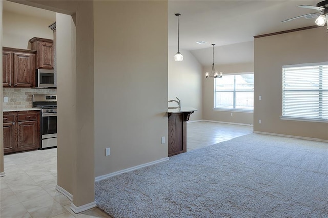 4536 Oasis Ct, Yukon, OK 73099 - unfurnished living room featuring a ceiling fan, vaulted ceiling, light colored carpet, baseboards, and a chandelier